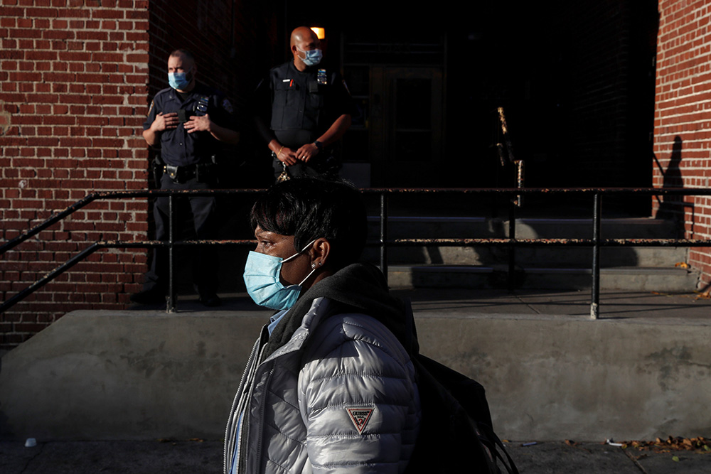 A woman walks past police officers in the Brooklyn borough of New York City Oct. 14, 2020. (CNS/Reuters/Shannon Stapleton) A woman walks past police officers in the Brooklyn borough of New York City Oct. 14, 2020. (CNS/Reuters/Shannon Stapleton)